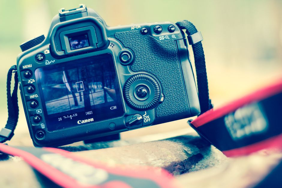 DSLR camera close-up with viewfinder focus grid displayed.
